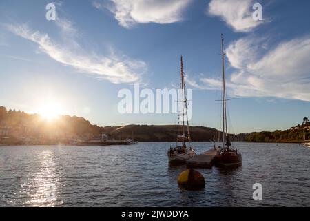 Abendlicht auf zwei klassischen Segelbooten aus Holz, die vor einem schwimmenden Ponton im River Dart, Dartmouth, festgemacht sind Stockfoto