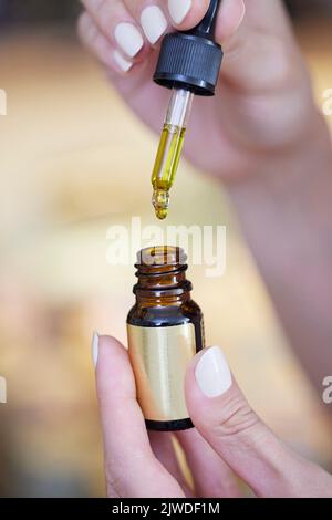 Nahaufnahme eines Hand Holding Droppers mit CBD-medizinischem Cannabisöl Stockfoto