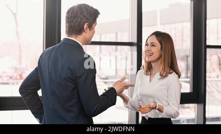 Lächelnde Frau und Geschäftsmann während des Vorstellungsgesprächs gestikulieren, Stockbild Stockfoto
