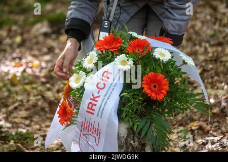 Neubrandenburg, Deutschland. 05. September 2022. Blumen werden an einer Gedenkstätte auf dem Gelände des ehemaligen Außenlagers Waldbau Neubrandenburg gelegt. Am selben Tag besuchen Frauen des Internationalen Ravensbrück-Komitees die Website. Im Lager mit zwei Standorten in Neubrandenburg mussten etwa 7000 Frauen unter den widrigsten Bedingungen leben und Zwangsarbeit verrichten. Das Ravensbrück-Komitee vereint Überlebende des Frauenkonzentrationslagers Ravensbrück mit ihren Kindern und Enkelkindern aus 16 Ländern. Quelle: Stefan Sauer/dpa/Alamy Live News Stockfoto