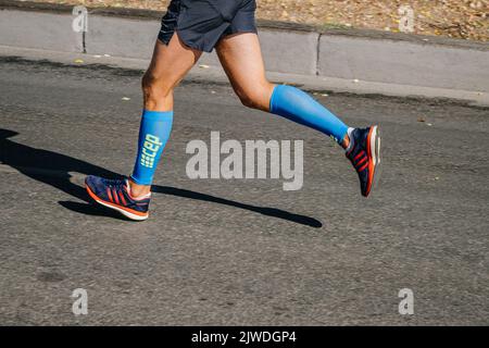 Jekaterinburg, Russland - 7. August 2022: Männer mit Beinen in Adidas-Schuhen und Kompressionsärmeln beim Europa-Asien-Marathon Stockfoto