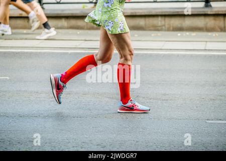 Jekaterinburg, Russland - 7. August 2022: Weibliche Läuferbeine in Kompressionssocken laufen beim Europa-Asien-Marathon Stockfoto