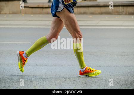 Jekaterinburg, Russland - 7. August 2022: Männliche Läuferbeine in Kompressionssocken laufen beim Europa-Asien-Marathon Stockfoto