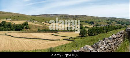 Blick über Mown Fields in Swaledale auf Gunnerside und Electric Gate Climb - ein steiler Fahrradhügel, Yorkshire Dales National Park, England, Großbritannien Stockfoto