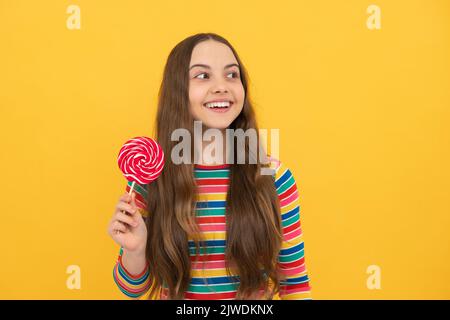 Hipster Teenager Kind Mädchen lecken Lollypop. Zucker Ernährung, Süßigkeiten und Süßigkeiten. Kind isst Lollipop-Popsicle. Stockfoto