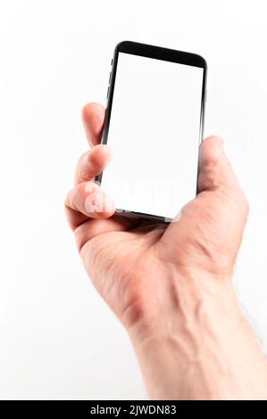 Mann Hand mit Smartphone auf weißem Hintergrund. Nahaufnahme der Hand eines Mannes, der ein Smartphone hält. Vertikales Bild Stockfoto