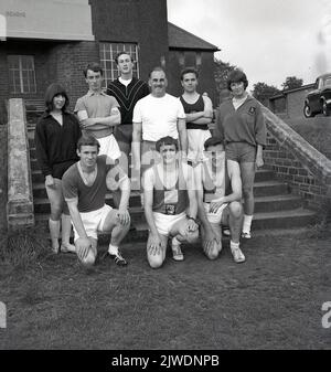 1960s, historische, junge Erwachsene Mitglieder eines Amateur-Sportclubs, posieren draußen für ein Gruppenfoto, mit ihrem männlichen Trainer, Schottland, Großbritannien. Stockfoto