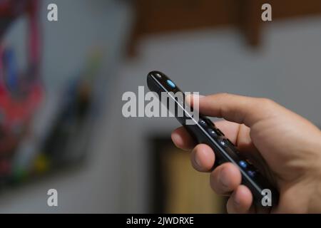 Mann stöbere in der Smart-tv-App, zappte Kanäle in der Freizeit, im technischen Lifestyle Stockfoto