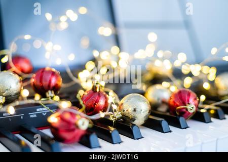 Eine bunte Kette von Lichtern liegt auf den Klaviertasten Stockfoto