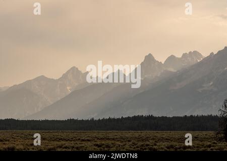 Smoky Teton Range erhebt sich aus Flat Valley unten im Grand Teton National Park Stockfoto