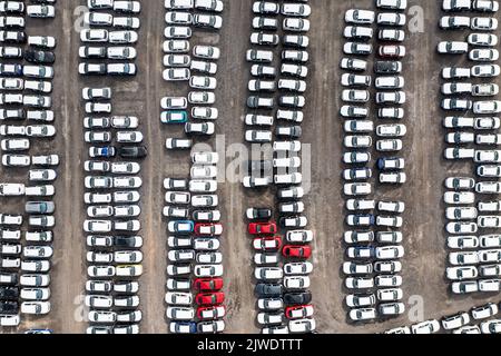 Eine Luftaufnahme von Reihen von neu gebauten Autos und Fahrzeugen bereit für den Export und Import und Lieferung an Verkaufshändler auf einem Hafen oder Terminal Dock Stockfoto