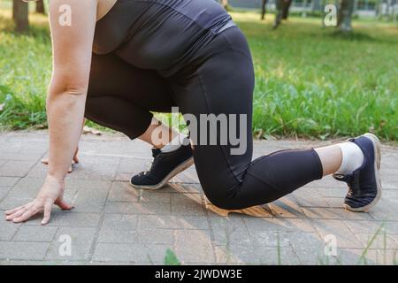 Eine charmante Brünette Frau plus-Größe Körper positiv praktiziert Sport in der Natur. Stockfoto