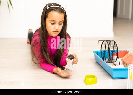 Kleines Mädchen, das einen Hamster in der Hand hält Stockfoto