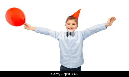 Kleiner Junge im Geburtstagshut mit blauem Ballon Stockfoto