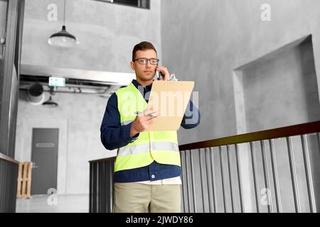 Männlicher Supervisor mit Anruf in der Zwischenablage am Telefon Stockfoto