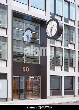 Übergroße Fassadenuhr mit Malzeit für Figuren am Haupteingang. 50 Eastbourne Terrace, London, Großbritannien. Architekt: Sheppard Robson, 2021. Stockfoto