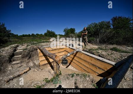 REGION SAPORISCHSCHSCHJA, UKRAINE - 02. SEPTEMBER 2022 - Ein Soldat wird an einer der Stellungen der ukrainischen Streitkräfte gesehen, wo sie die Verteidigungseinrichtungen durch die Installation von Metallbunkern, Saporischschschja, Südostukraine, verbessern. Stockfoto