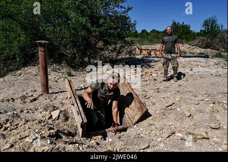 REGION SAPORISCHSCHSCHJA, UKRAINE - 02. SEPTEMBER 2022 - Soldaten werden an einer der Positionen der ukrainischen Streitkräfte gesehen, wo sie die Verteidigungseinrichtungen durch die Installation von Metallbunkern, Saporischschschja, Südostukraine, verbessern. Stockfoto