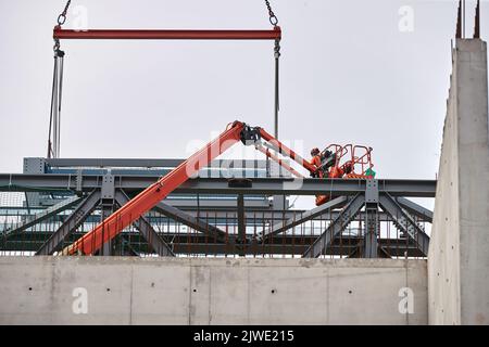 Zwei Bauherren in einem Cherry Picker Korb inspizieren die Baustelle der Anfield Road im September 2022 Stockfoto