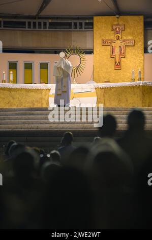 Ein Priester segnet die Gläubigen mit dem Allerheiligsten Sakrament am Ende der eucharistischen Anbetung in Medjugorje, Bosnien und Herzegowina. Stockfoto