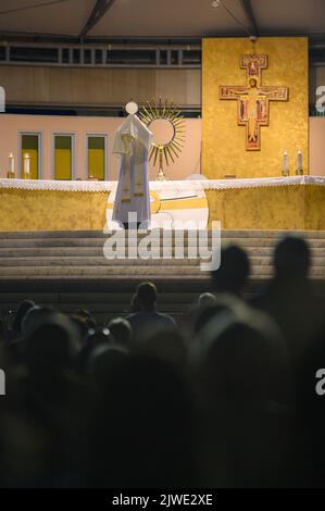 Ein Priester segnet die Gläubigen mit dem Allerheiligsten Sakrament am Ende der eucharistischen Anbetung in Medjugorje, Bosnien und Herzegowina. Stockfoto