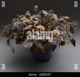 Bouquet von getrockneten Blumen in Keramikvase auf neutralem Hintergrund Stockfoto