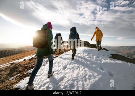 Gruppe von jungen Touristen Wanderer Spaziergänge auf der Bergspitze mit Rucksäcken. Konzept des aktiven Lebens Stockfoto