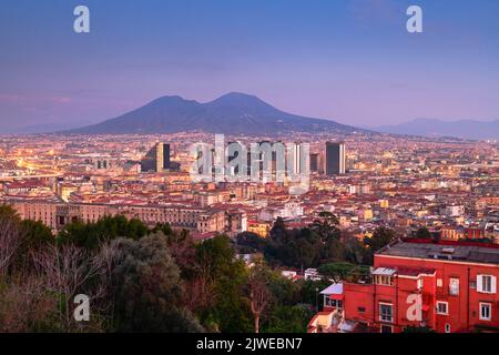 Neapel, Italien mit der Skyline des Finanzviertels unter dem Berg Vesuv in der Dämmerung. Stockfoto