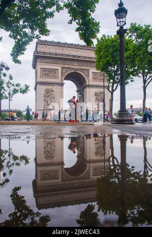 Der Triumphbogen in Paris an einem regnerischen Tag. Die Struktur spiegelt sich in einer großen Pfütze wider Stockfoto