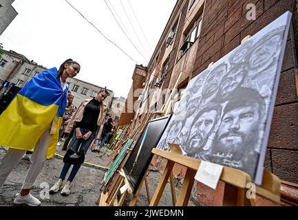 ZAPORIZHZHIA, UKRAINE - 04. SEPTEMBER 2022 - die Besucher sehen sich die Kunstwerke an, die während des Ausstellungsverkaufs zur Unterstützung der gefangenen Verteidiger von Asowstal, Zaporizhzhia, Südost-Ukraine, präsentiert wurden. Stockfoto