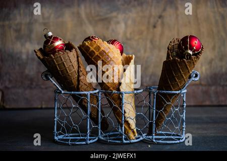 Nahaufnahme von drei konzeptuellen Eiszapfen mit Weihnachtskugeln Stockfoto