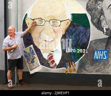 Paul Cable, Zeitungsredaktion und lokaler Künstler von Abergavenny, steht neben einem Wandgemälde, das er in der Stadt gemalt hat, mit Kapitän Sir Tom Moore und Dame Vera Lynn. Stockfoto