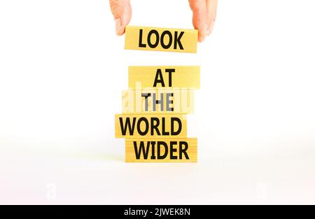 Schauen Sie sich das Symbol der Welt an. Konzeptwörter blicken auf die Welt breiter auf Holzblöcken auf einem schönen weißen Hintergrund. Geschäftsmann Hand. Business und Stockfoto