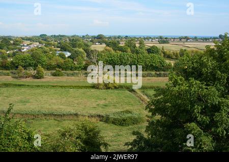 Blick über die Landschaft von East Sussex von der Hügelstadt Winchelsea, Südostengland, mit Blick auf den Winchelsea Beach und das Meer Stockfoto