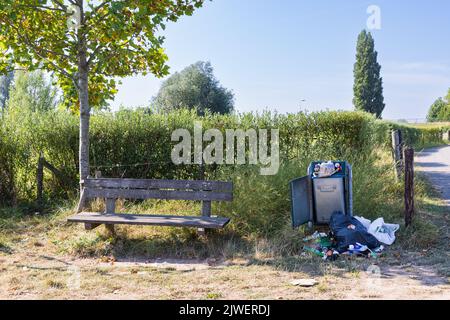 Überlaufender öffentlicher Müll- und Abfalleimer am Picknickplatz am Niederrhein in Lienden Gelderland Stockfoto