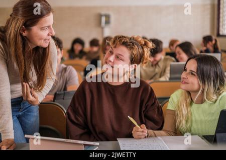 Die Lehrerin erklärt ihren Studenten an der Universität individuell Stockfoto