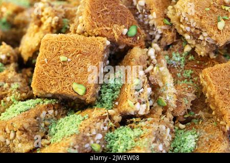 Baklava mit Pistazien und Erdnüssen, süßer Hintergrund. Traditionelles türkisches und arabisches Dessert Kunafa mit Pistazien, Nüssen und Honig Stockfoto