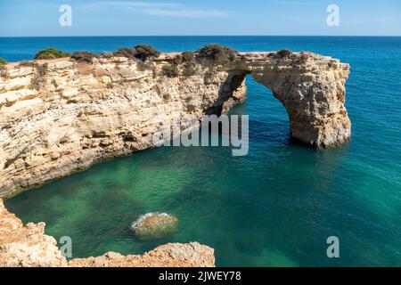 Natürlicher Bogen von Albandeira bei Ebbe. Wahrzeichen in Lagoa, Algarve. Stockfoto
