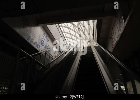 Bukarest, Rumänien - 3. September 2022: Ein älterer Mann geht eine dunkle, schmutzige und zerstörte Treppe in Bukarest hinunter. Stockfoto