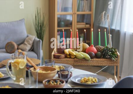 Horizontales Bild von Tablett mit Kerzen und exotischen Früchten stehen auf Esstisch Vorbereitung für die Feier des Urlaubs Stockfoto