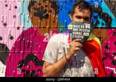 Goiânia, Goias, Brasilien – 05. September 2022: Ein Junge, der einen Fan mit dem Text hält: "Mehr als Widerstand zu leisten, werden wir existieren." Aufnahme während der LGBTQIA+ Stockfoto