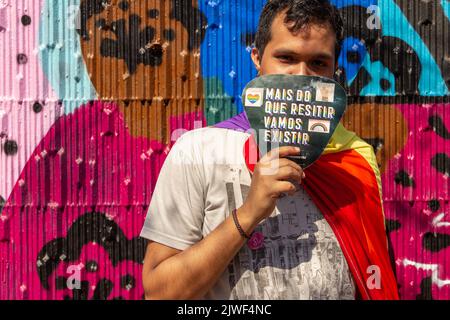 Goiânia, Goias, Brasilien – 05. September 2022: Ein Junge, der einen Fan mit dem Text hält: "Mehr als Widerstand zu leisten, werden wir existieren." Aufnahme während der LGBTQIA+ Stockfoto