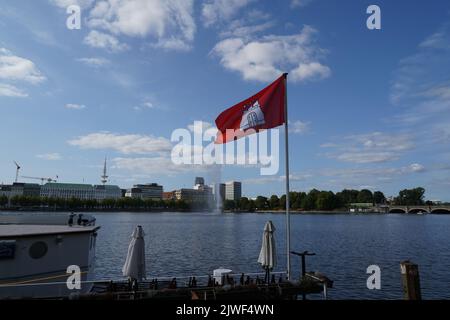 Flagge Hamburgs, weißes Schloss mit drei Türmen auf rotem Hintergrund, im Restaurant auf dem Festboot in der Binnenalster gehisst. Stockfoto