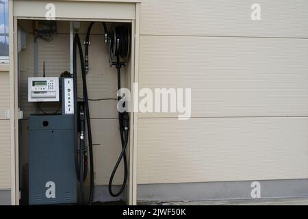 Diesel-Tankstelle in der Wand des cremefarbenen Industriegebäudes zum Nachfüllen aller Güter-Lkw. Stockfoto