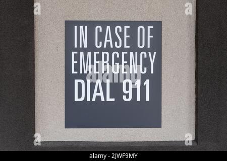 Graues Schild an der Wand mit der Notrufnummer, Schild mit Aufschrift: Im Notfall wählen Sie 911 Stockfoto