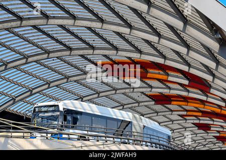 Amsterdam, Niederlande - August 2022: Öffentlicher Bus fährt unter seinem geschwungenen Dach am Amsterdam Centraal in den Busbahnhof ein. Stockfoto