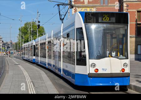 Amsterdam, Niederlande - August 2022: Moderne elektrische Straßenbahn an einer Straßenbahnhaltestelle vor dem Hauptbahnhof der Stadt Stockfoto