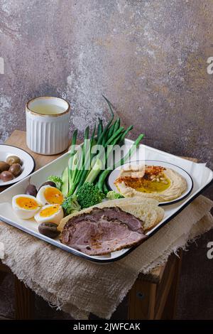 Frühstück mit hinterem Fleisch, Hummus und grünem Gemüse, Kopierplatz Stockfoto