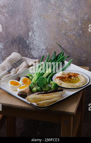 Frühstück mit hinterem Fleisch, Hummus und grünem Gemüse, Kopierplatz Stockfoto