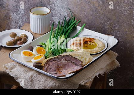 Frühstück mit hinterem Fleisch, Hummus und grünem Gemüse, Kopierplatz Stockfoto
